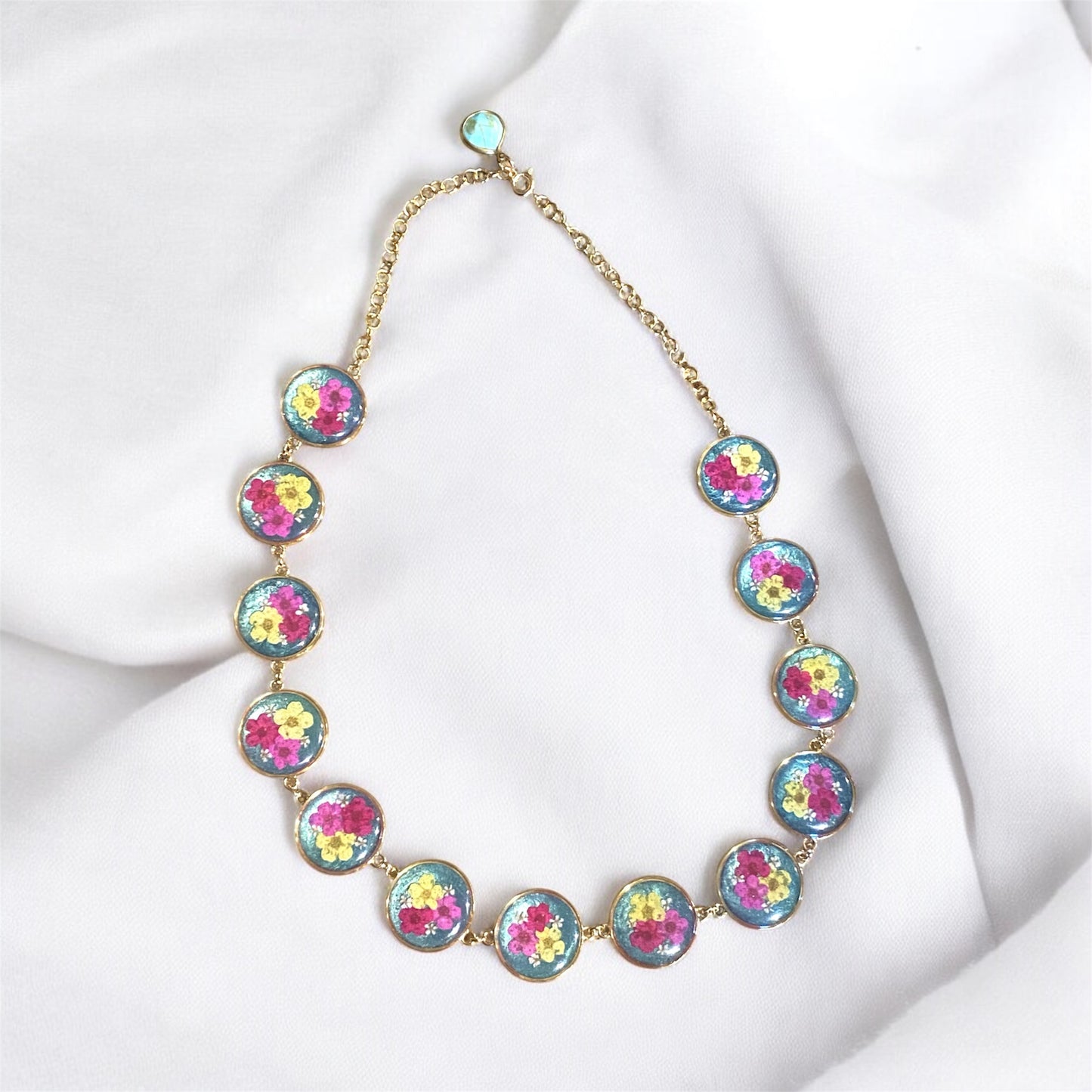 Teal colored Mica Powder with Yellow, and Pink Plum Blossoms with pieces of Queen Anne’s Lace