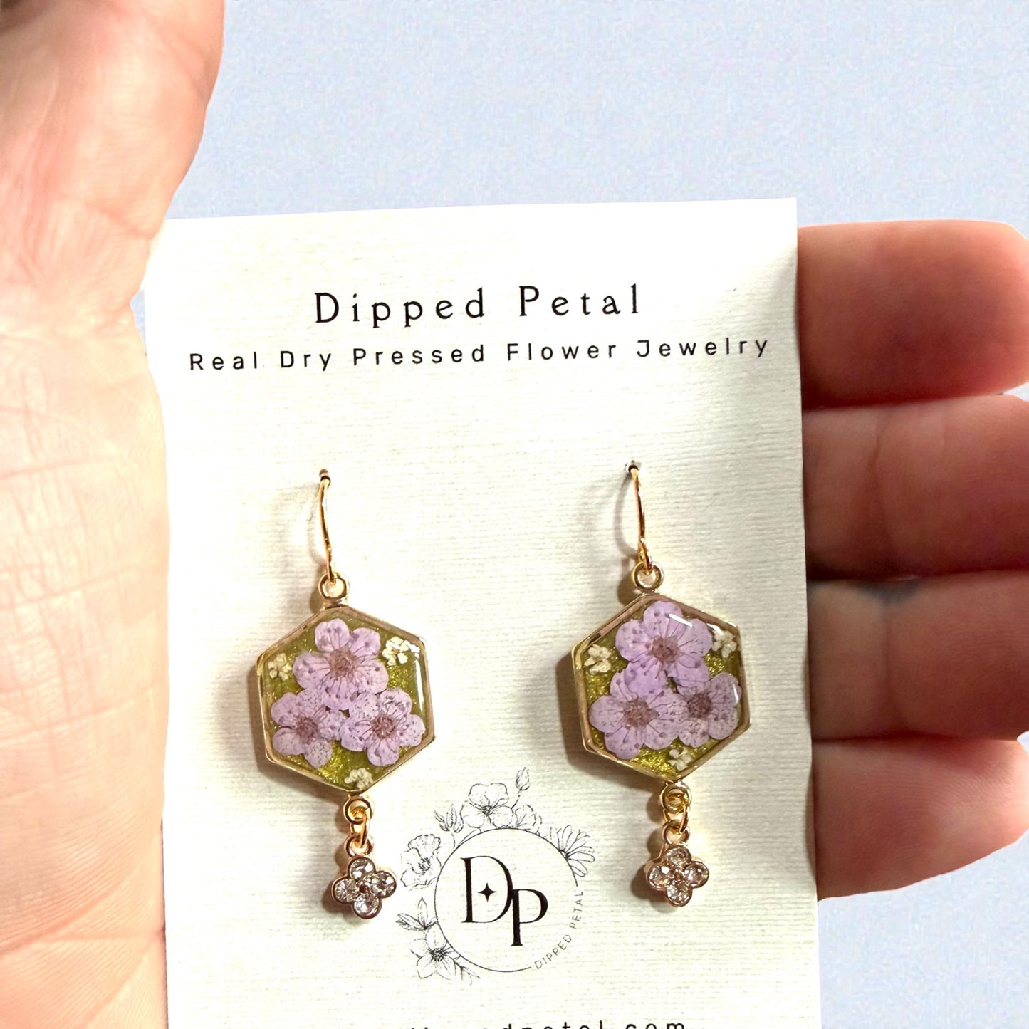 Green Colored Mica Powder Background with Light Purple Plum Blossoms and Pieces of Queen Anne’s Lace