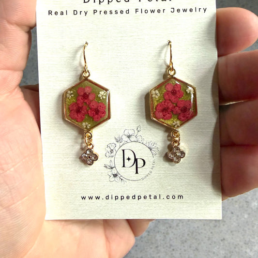 Green Colored Mica Powder Background with Red Plum Blossoms and Pieces of Queen Anne’s Lace